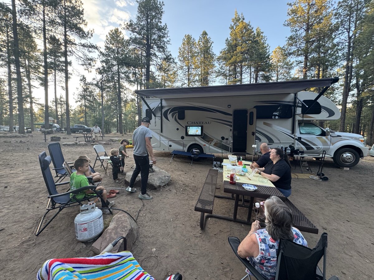 Family gathered around an RV watching the World Cup outdoors
